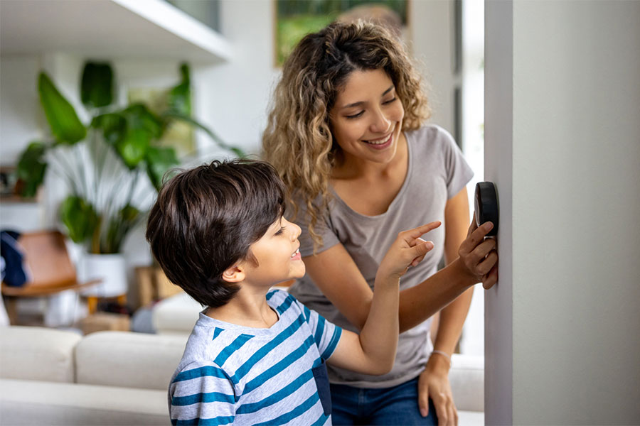 Mom and Son adjusting smart thermostat