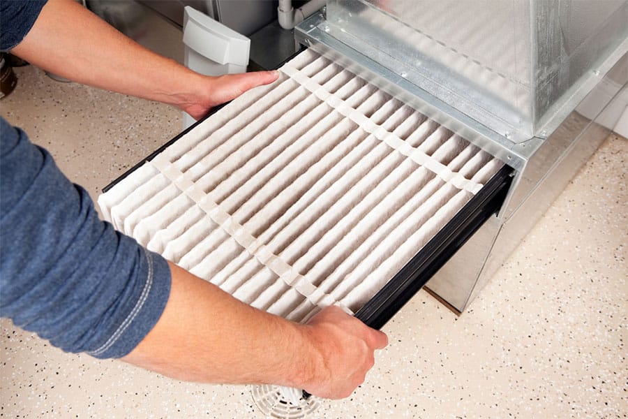 Hands pulling Furnace Filter out
